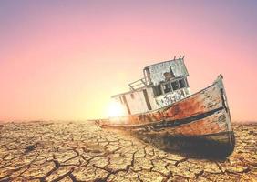 Boats on a barren land. A ship on a broken land. The concept of drought, global warming and the environment. photo