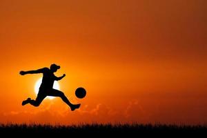 Silhouette of football players in the evening. Football concept is popular all over the world. photo