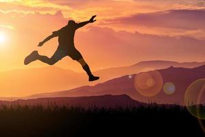 The silhouette of a man is jumping forward. The concept of clawing through hurdles photo