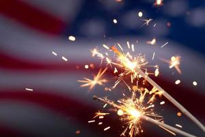 Burning sparklers against USA flag. Celebrating US national holiday with sparklers photo