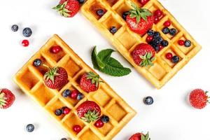 Top view, belgium waffles with fresh berries and mint leaves on a white background photo