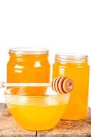 fondo con miel de abeja natural en frascos de vidrio y un tazón