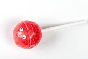 Red lollipop with eyes on a white background