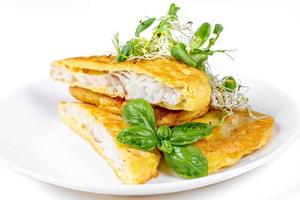 Delicious fried fish in batter with fresh microgreens photo