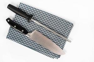 Knife and Knife Sharpener on the kitchen dishcloth on the white background photo