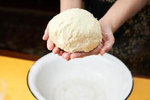Woman finishing dough prepares in the kitchen