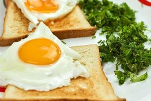huevos fritos sobre las tostadas. delicioso desayuno lleno de vitaminas y nutrición