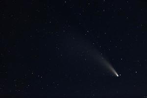 A comet passing near the earth with a glowing tail photo