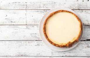 Tasty homemade cheesecake on white wooden table photo