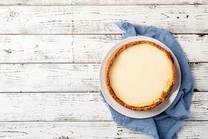 Tasty homemade cheesecake on white wooden table photo