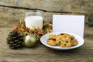 cookies and a glass with milk with a white note for santa photo