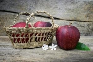 Basket with apples on grunge wooden background photo