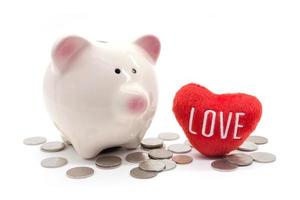 piggy bank with heart and coin on white background photo