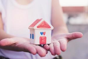 Small kid hands holding house photo