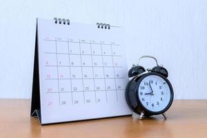 calendario con dias y reloj en mesa de madera