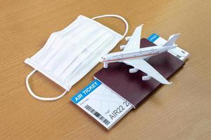 Travel during the covid-19 pandemic. airplane model with face mask, air ticket and passport. ready for holidays. photo