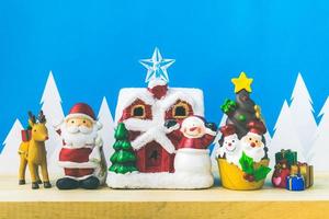 muñecos de santa claus y caja de adornos navideños en madera foto