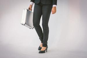 mujer inteligente con traje negro sostiene un maletín foto