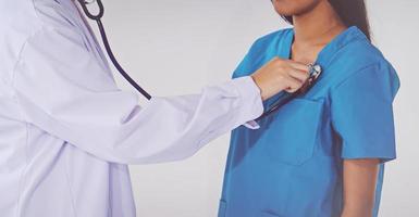 doctor with stethoscope examining heart photo