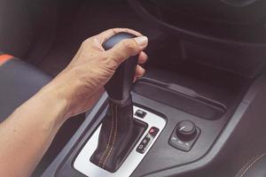 driver man hand holding automatic transmission in car photo