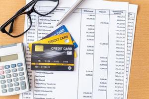 Credit cards and  Calculator on Bank statement on a Wooden table photo