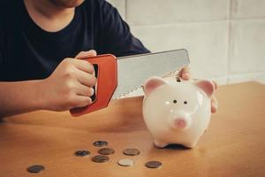 Little boy breaking a piggy bank photo