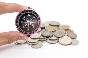 compass and coins on white background photo