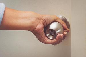 Asian women hand open door knob photo