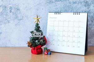 calendario de diciembre y decoración navideña - santa claus, árbol y regalo en mesa de madera. concepto de navidad y feliz año nuevo foto