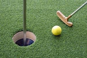 Golf ball and golf club on artificial grass. photo