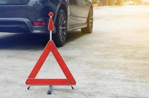 Broken car sign on a road with a broken down car photo