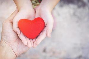 Small kid hands holding heart photo