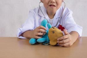 Asian boy playing as a doctor care bear doll photo