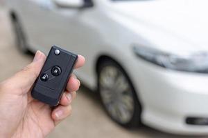 Man holding car keys with car on background photo