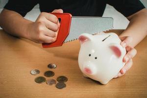 Little boy breaking a piggy bank photo