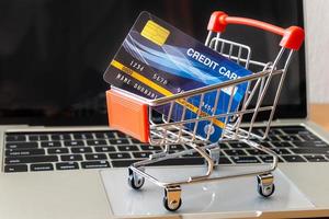 credit card and cart supermarket on wood table. shopping concept photo