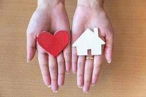 woman hands holding red heart and icon house photo