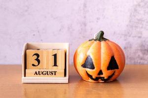 bloque de calendario de madera interrumpido mostrar fecha 31 de octubre día de halloween y calabaza de juguete sobre fondo de madera. concepto de halloween
