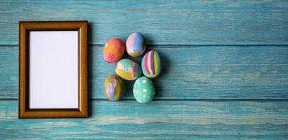 Picture frame and colorful easter eggs. Easter festive holidays concept. photo