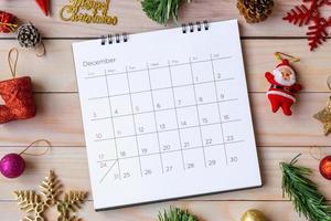 calendario de diciembre y decoración navideña - santa claus y regalo en mesa de madera. concepto de navidad y feliz año nuevo