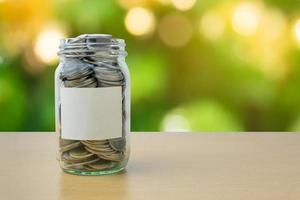 Money bottle with coins on bokeh background photo