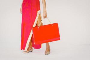 Asian woman holding shopping bag, woman wear cheongsam, chinese new year photo