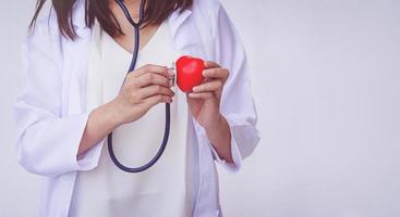 médico con estetoscopio examinando el corazón rojo foto