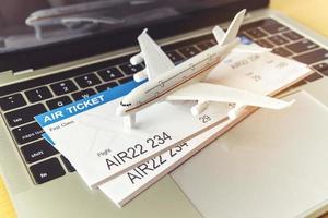 laptop computer and airplane and money on table. Online ticket booking concept photo