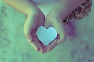 Children hands holding small model of heart and family , concept family photo