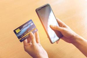 Woman holding credit card and smartphone. On-line shopping on the internet using a smartphone photo