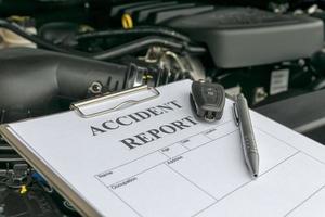 Mechanic Inspecting damage car and filling in accident report form photo