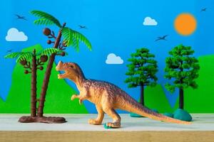 modelo de juguete de dinosaurio tiranosaurio sobre fondo de modelos salvajes foto