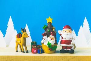 muñecos de santa claus y caja de adornos navideños en madera foto