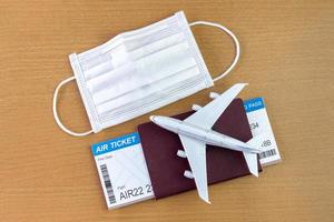 Travel during the covid-19 pandemic. airplane model with face mask, air ticket and passport. ready for holidays. photo